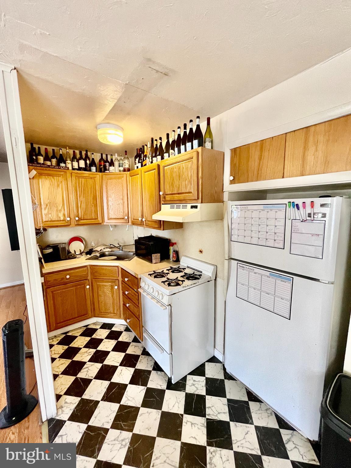 4167 Terrace Street, Unit A Philadelphia, PA 19128 - Photo 7 of 15 a kitchen with a stove a sink and a refrigerator