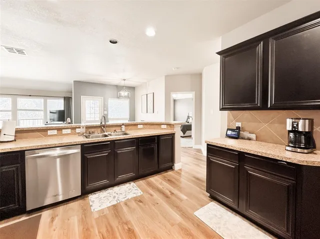 a large kitchen with kitchen island granite countertop a sink dishwasher stove and cabinets