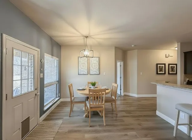 a dining room with furniture a chandelier and wooden floor