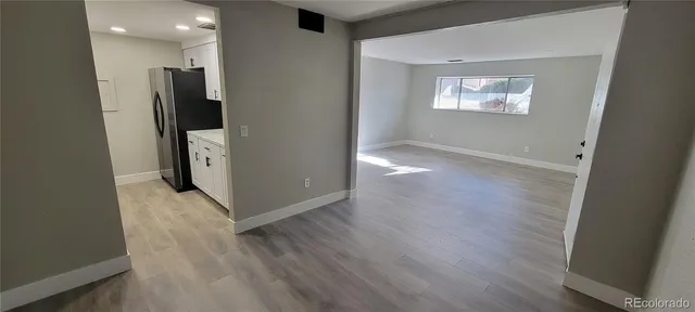 an empty room with wooden floor and a window