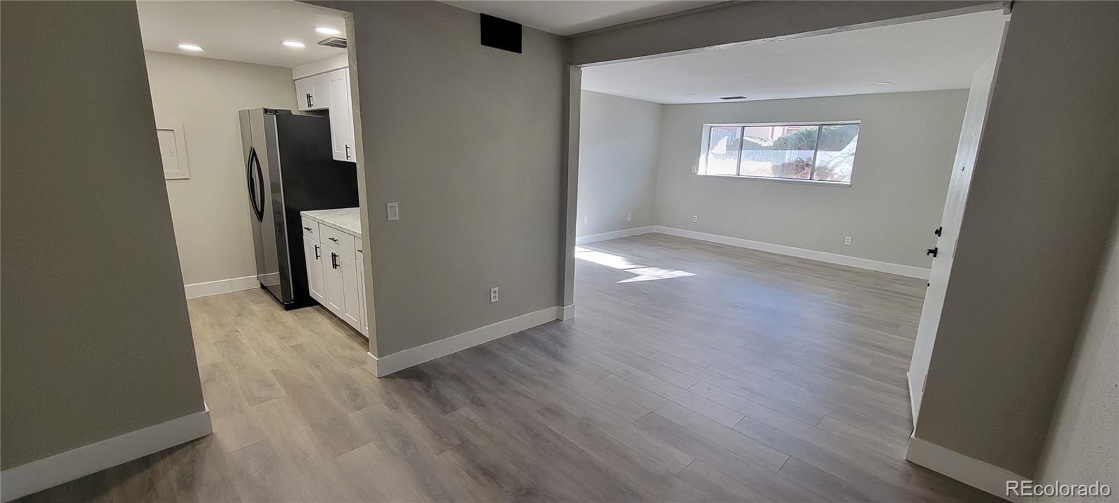 12140 Huron Street, Unit 101 Denver, CO 80234 - Photo 4 of 19 an empty room with wooden floor and a window