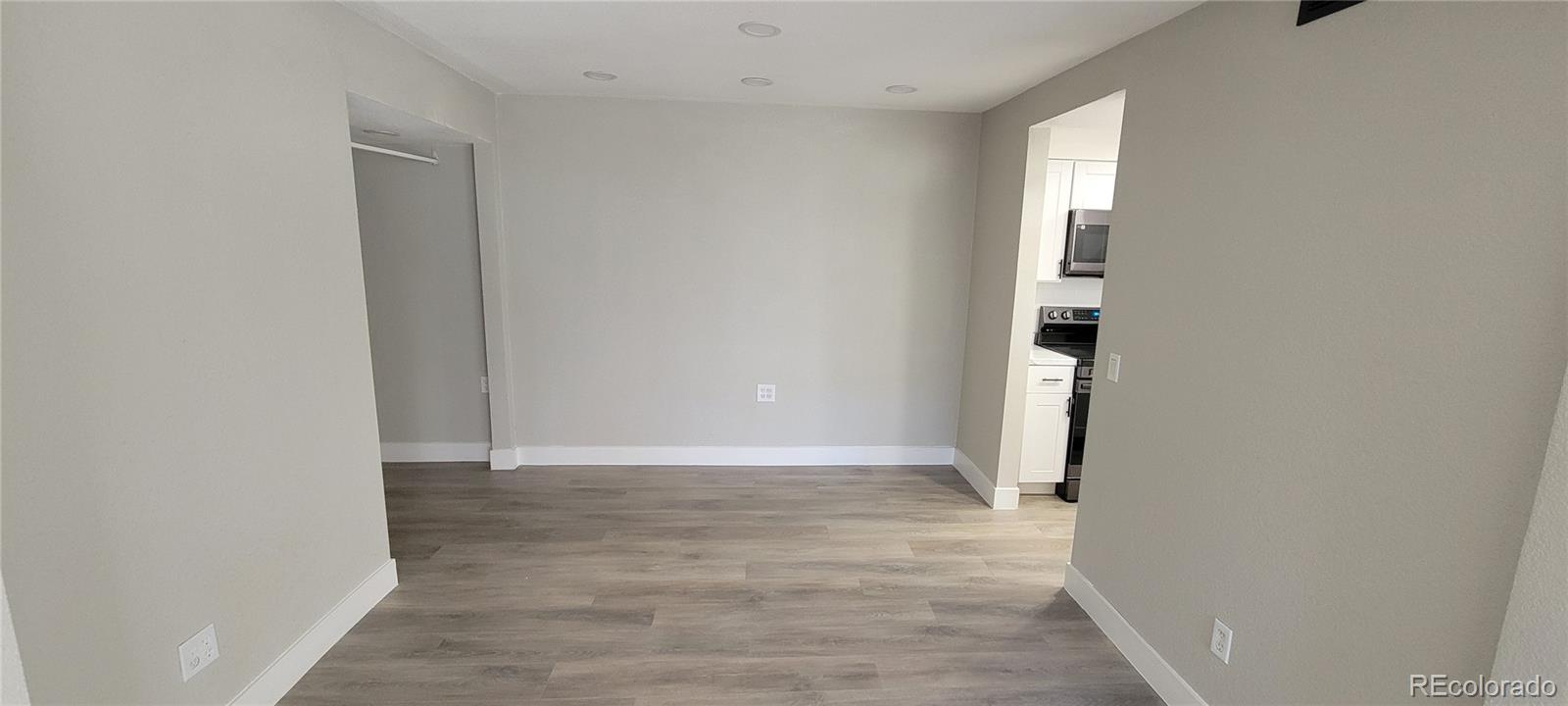 12140 Huron Street, Unit 101 Denver, CO 80234 - Photo 5 of 19 a view of an empty room with wooden floor and a window