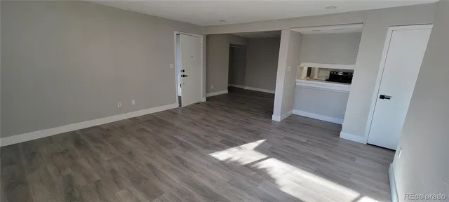 a view of a hallway with wooden floor and closet