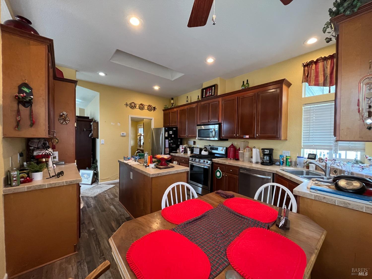 54 Norfolk Drive Santa Rosa, CA 95401 - Photo 26 of 57 a kitchen with granite countertop a stove top oven a sink dishwasher a dining table and chairs with wooden floor