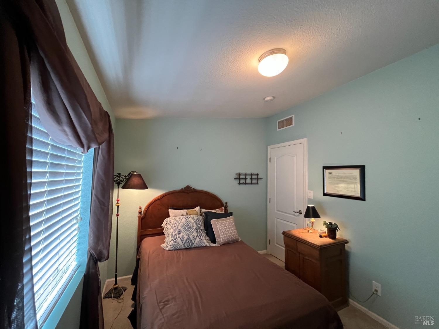 54 Norfolk Drive Santa Rosa, CA 95401 - Photo 35 of 57 a bedroom with a bed and a lamp on dresser
