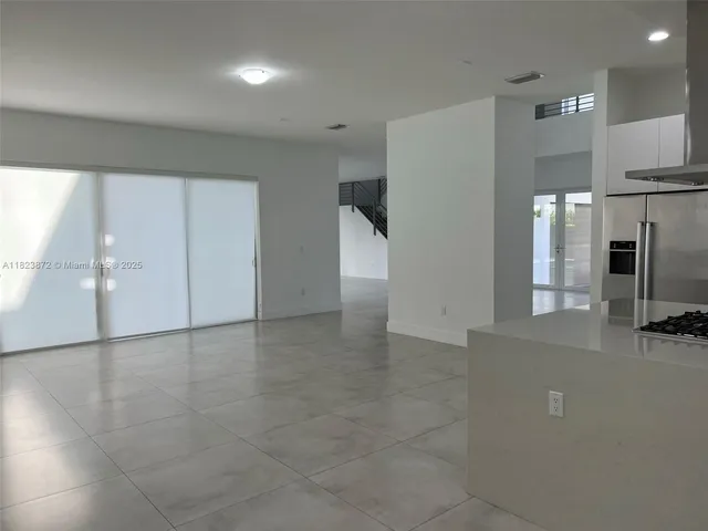 a view of a kitchen with a sink and a refrigerator