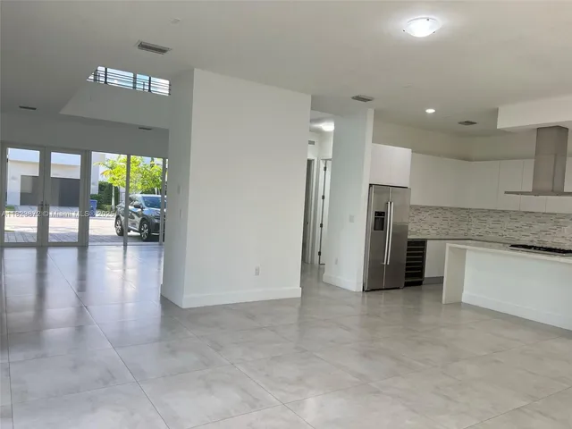 a view of a kitchen with a sink and a refrigerator