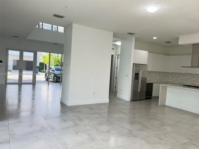 a view of a kitchen with a sink and a refrigerator