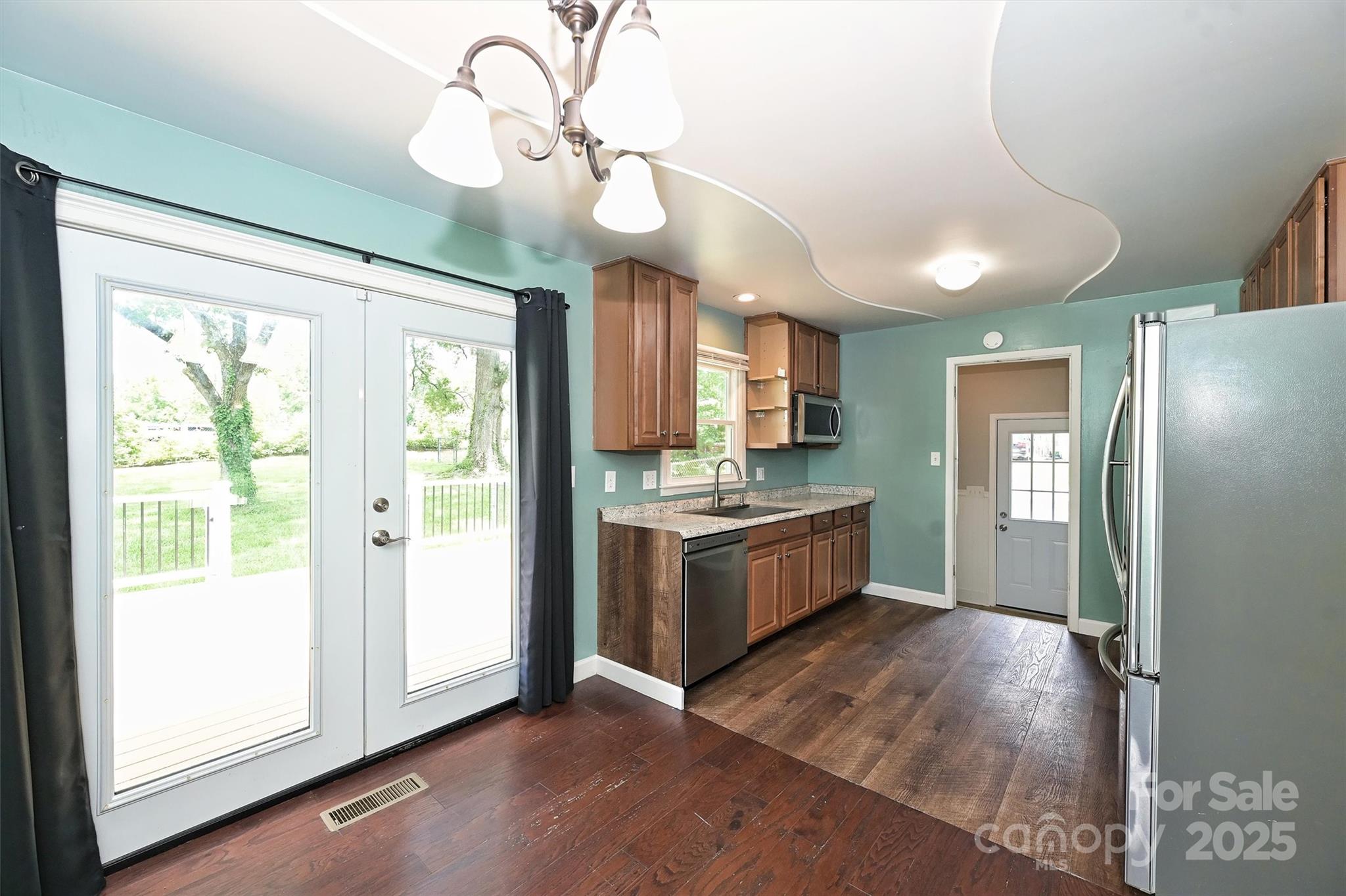 3729 Woodleaf Road Charlotte, NC 28205 - Photo 5 of 23 a large kitchen with a large window a refrigerator and stainless steel appliances