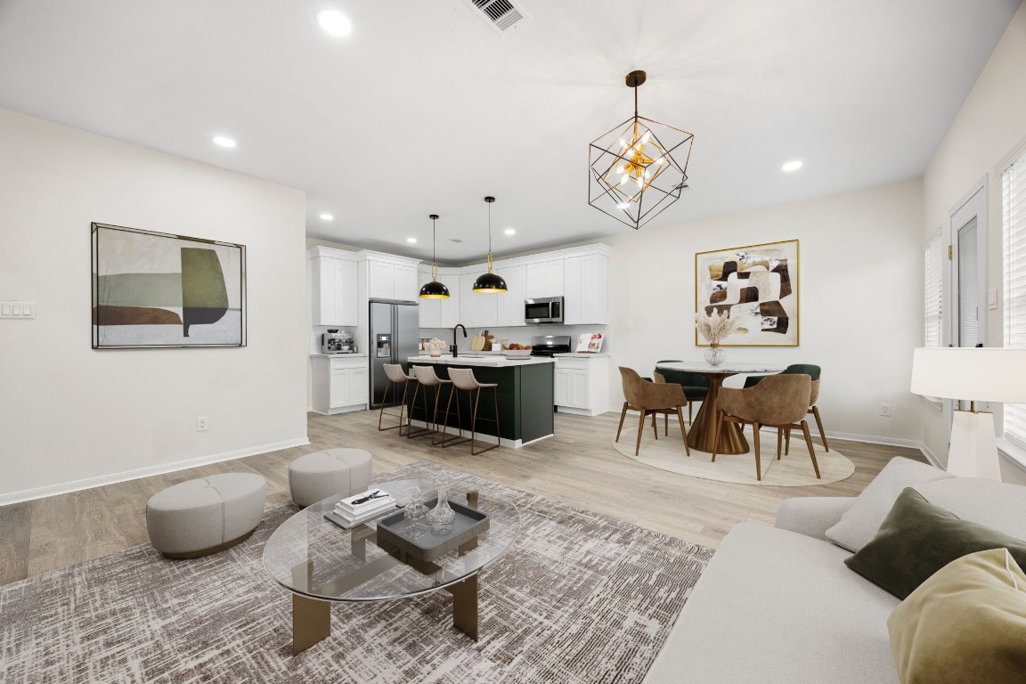 13735 Sablegarden Lane Houston, TX 77014 - Photo 4 of 20 A bright and beautifully staged living space showcasing an open layout with a modern kitchen, spacious dining area, and comfortable seating. Clean lines, stylish lighting, and warm finishes create an inviting atmosphere perfect for relaxing or entertaining.