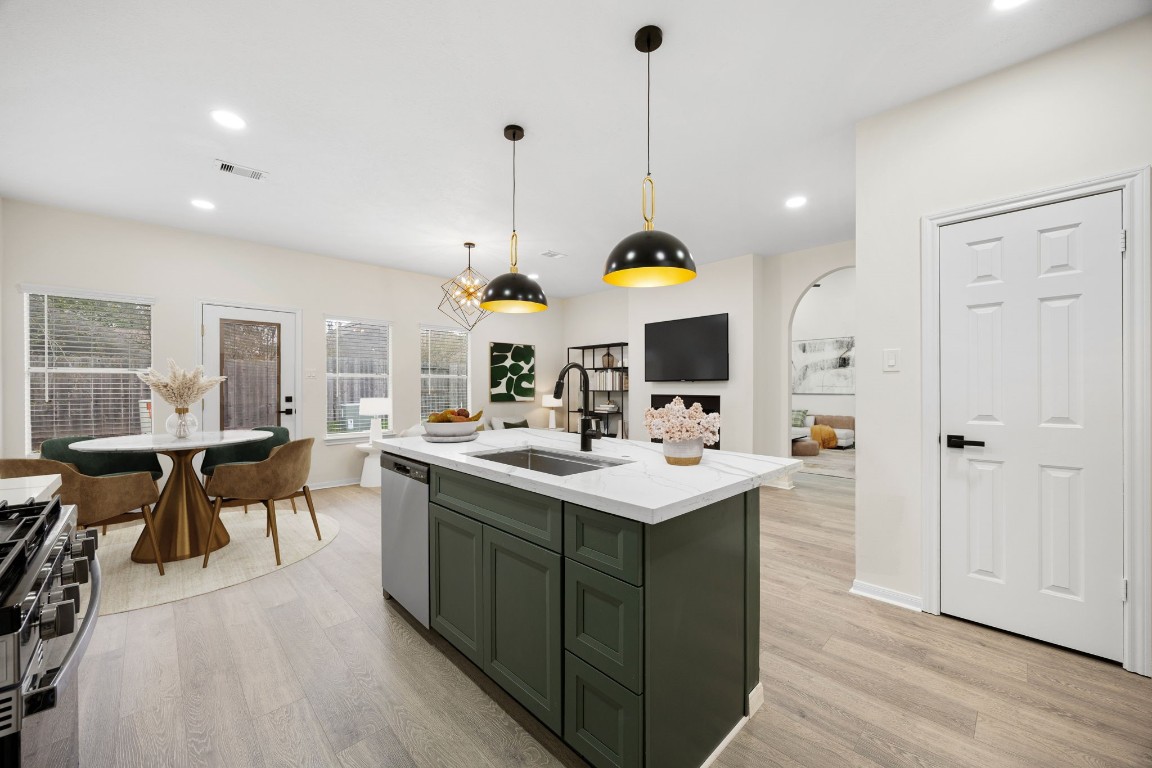 13735 Sablegarden Lane Houston, TX 77014 - Photo 6 of 20 Spacious kitchen with a large center island, modern lighting, and an open layout that flows naturally into the dining and living areas. Bright windows and neutral finishes create a welcoming space perfect for cooking, gathering, and everyday living.