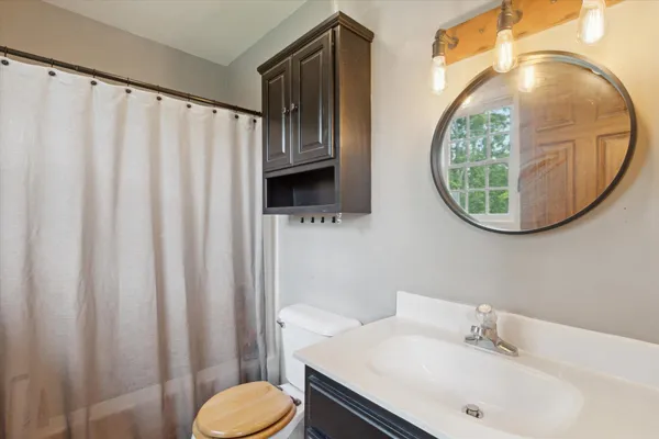 a bathroom with a sink toilet and mirror