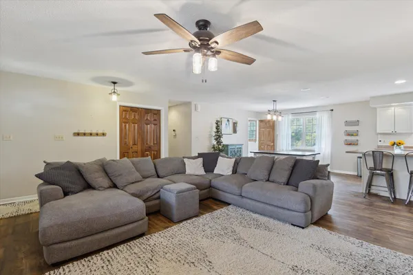 a living room with furniture and a large window with wooden floor