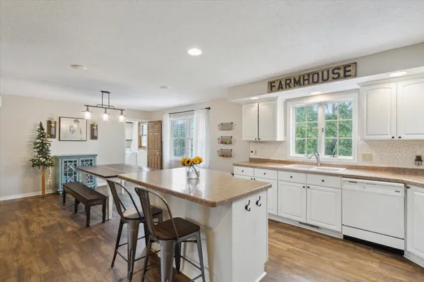 a kitchen with a table chairs sink and cabinets