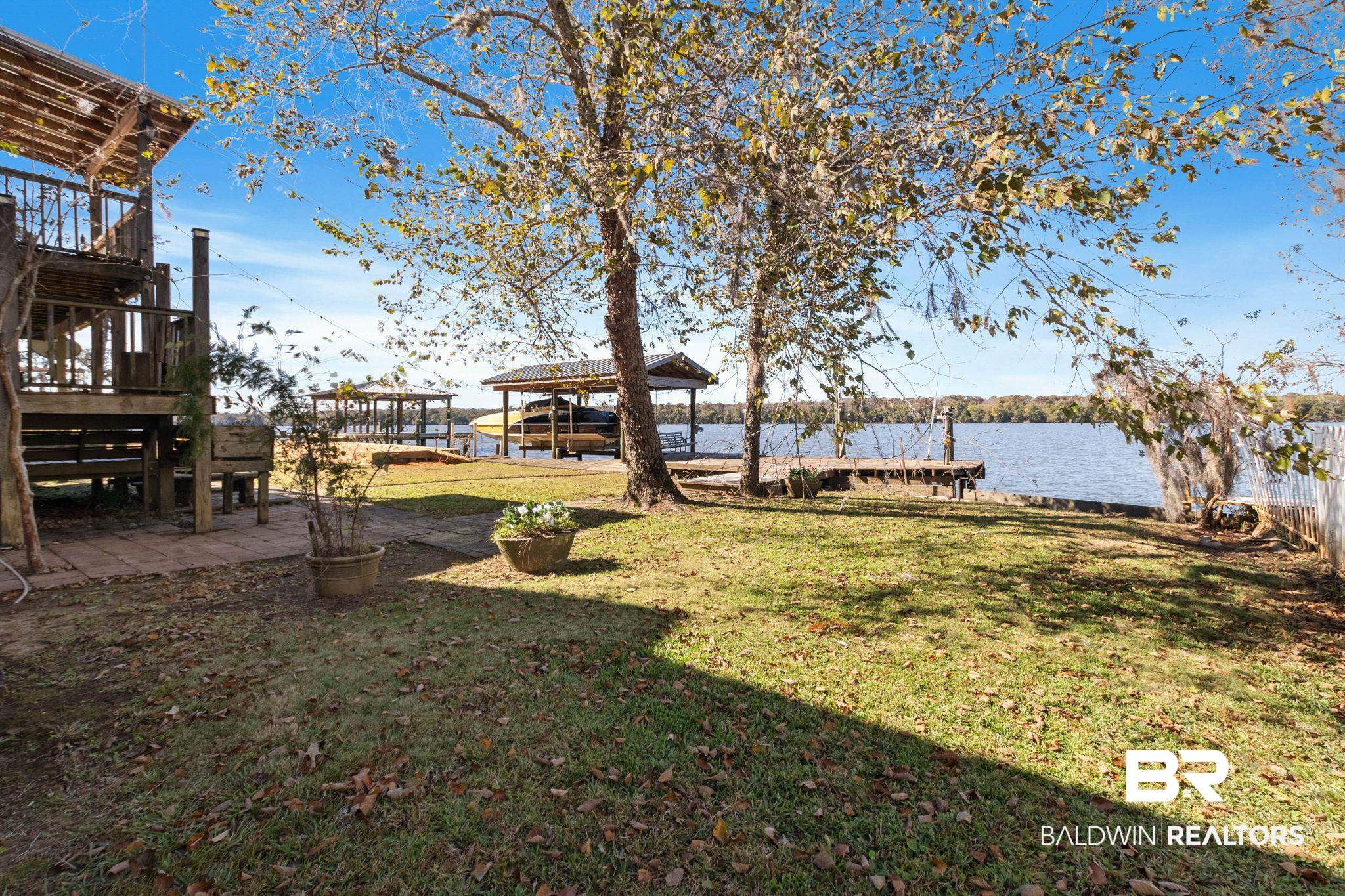 41997 Bayou Road Bay Minette, AL 36507 - Photo 58 of 68 View of green lawn featuring a boat dock, a water view, and a patio
