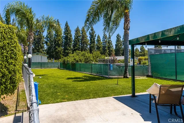 a view of a backyard with swimming pool and sitting area