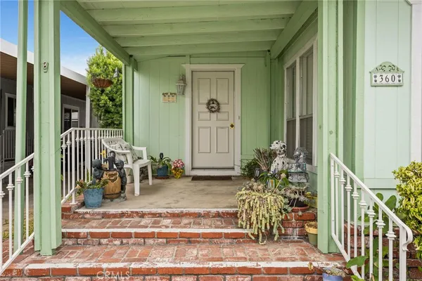 a view of a porch with chairs and potted plants
