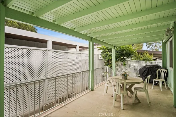 a view of a patio with table and chairs with wooden floor fence and roof