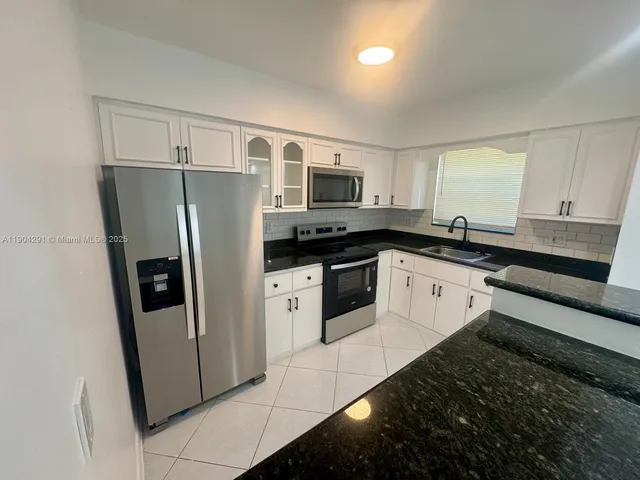 a kitchen with stainless steel appliances a refrigerator a sink a stove a microwave and island