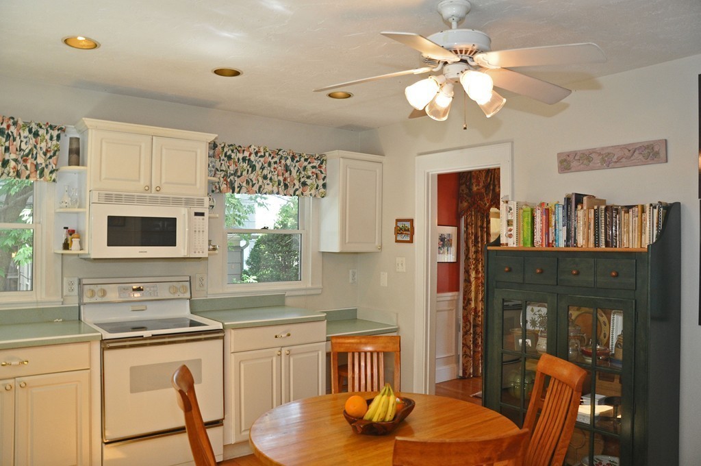 69 Reedsdale Road Milton, MA 02186 - Photo 8 of 13 a kitchen with stainless steel appliances granite countertop a stove a sink a dining table and chairs
