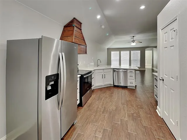 a kitchen with stainless steel appliances a refrigerator and a stove top oven