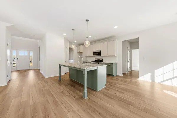 a large kitchen with cabinets wooden floor and stainless steel appliances