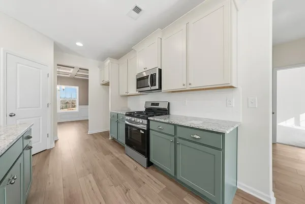 a kitchen with stainless steel appliances granite countertop a stove a sink and a refrigerator