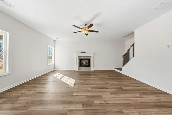 a view of an empty room with a fireplace and a window