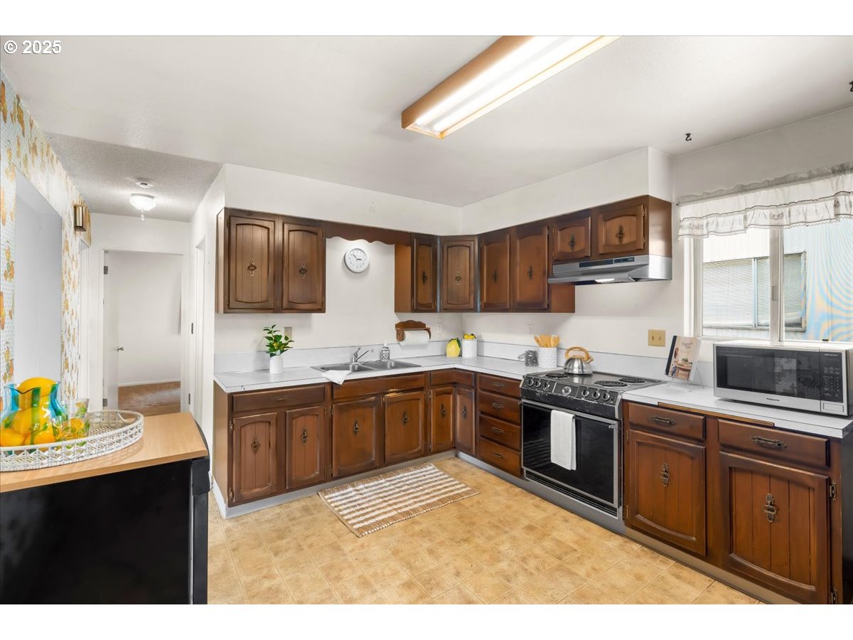 46389 Southwest Patton Valley Road Gaston, OR 97119 - Photo 6 of 48 a kitchen with stainless steel appliances granite countertop a sink dishwasher stove top oven and cabinets with wooden floor
