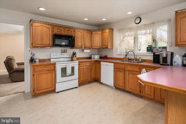 a large kitchen with a stove a sink dishwasher and a refrigerator