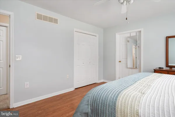 a spacious bedroom with a bed and a dresser