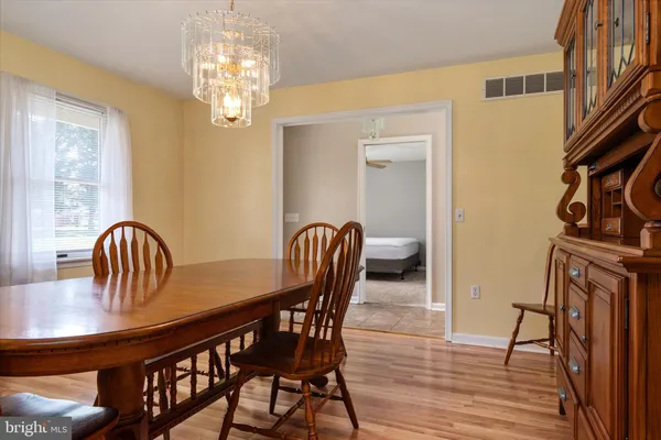 a dining room with furniture a chandelier and wooden floor