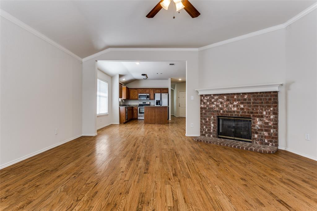 9710 Revolution Way Frisco, TX 75033 - Photo 16 of 25 an empty room with wooden floor fireplace and windows