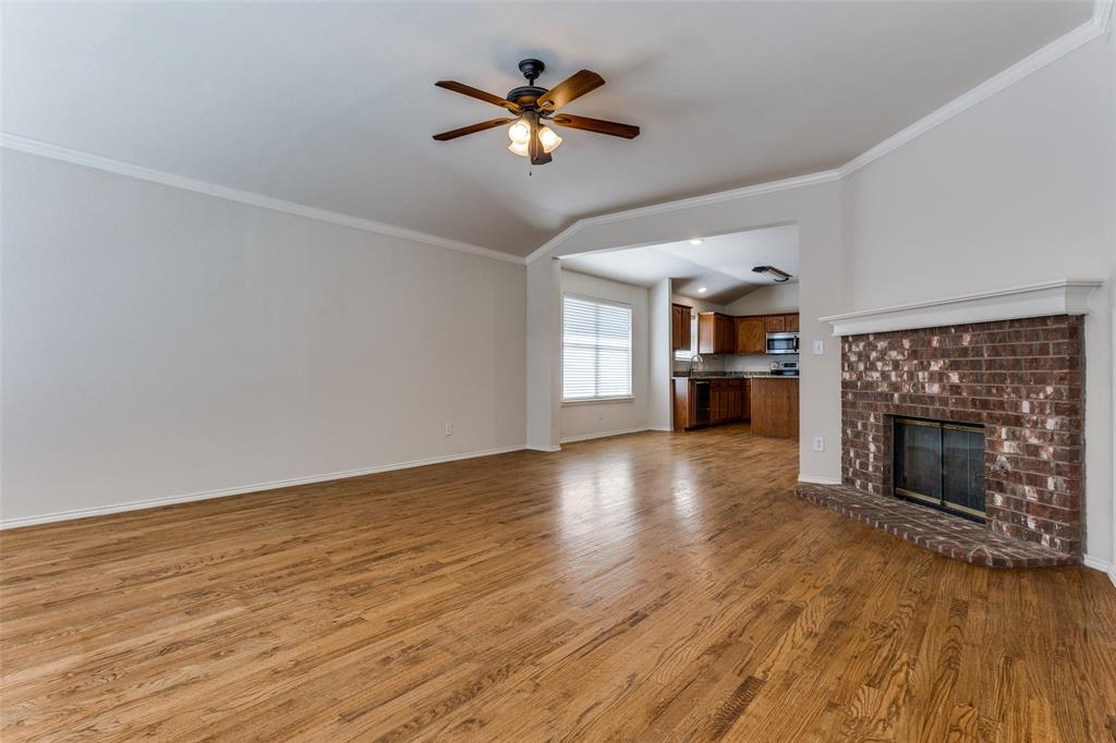 9710 Revolution Way Frisco, TX 75033 - Photo 17 of 25 an empty room with fireplace chandelier fan and windows