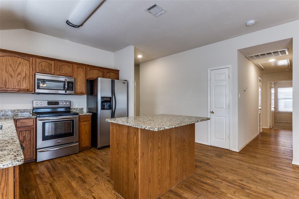 9710 Revolution Way Frisco, TX 75033 - Photo 2 of 25 a kitchen with stainless steel appliances granite countertop a stove and a refrigerator