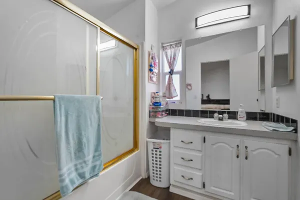 a bathroom with a granite countertop sink a toilet and shower