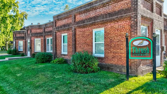 a view of a brick house with a large windows and a yard