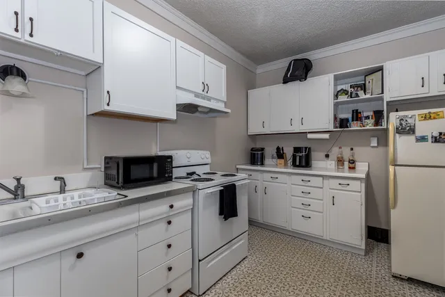 a kitchen with white cabinets sink and white appliances