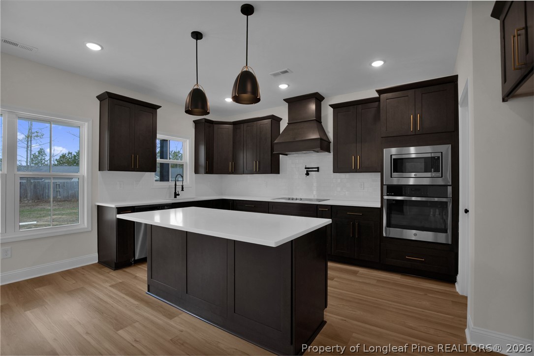 116 Surveyor Street Raeford, NC 28376 - Photo 14 of 45 a kitchen with stainless steel appliances granite countertop a sink a stove and a wooden floors