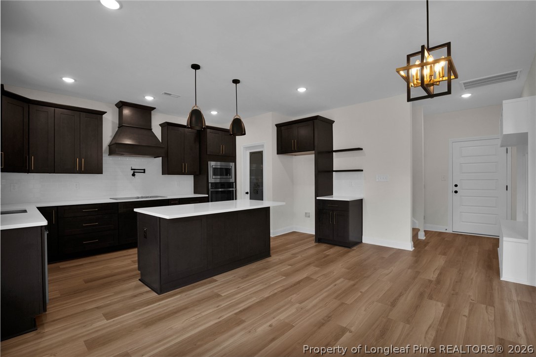 116 Surveyor Street Raeford, NC 28376 - Photo 19 of 45 a large kitchen with stainless steel appliances a large counter top a stove and a wooden floors