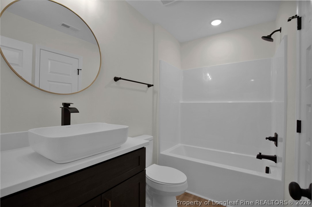 116 Surveyor Street Raeford, NC 28376 - Photo 32 of 45 a bathroom with a sink a toilet and a mirror