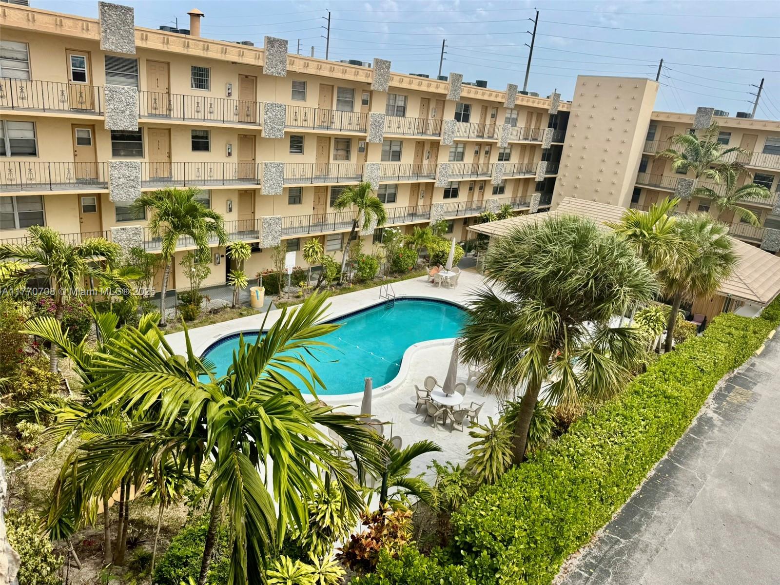 2145 Pierce Street, Unit 403 Hollywood, FL 33020 - Photo 1 of 10 a view of a tall building with a yard and lawn chairs