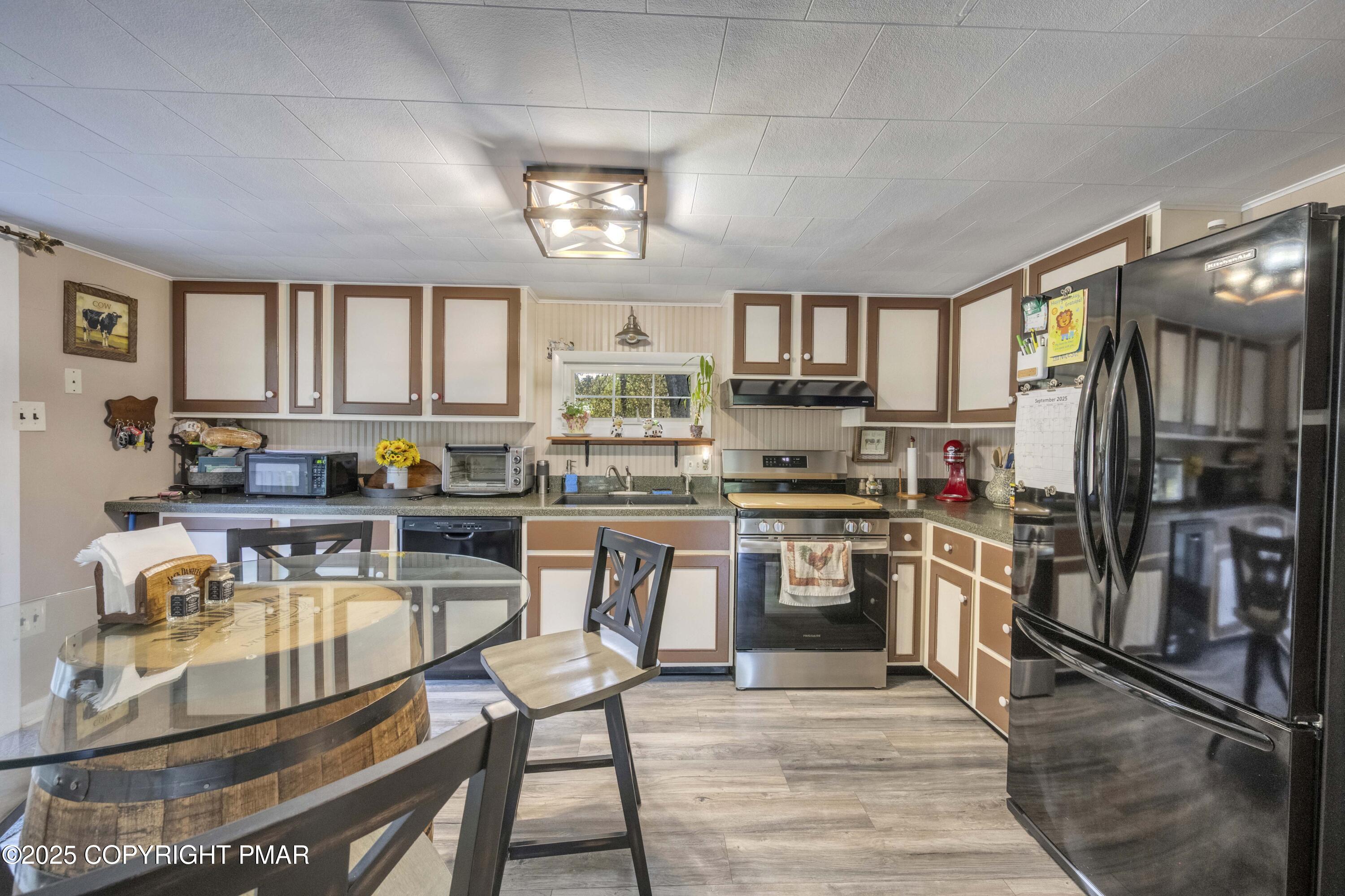 117 Streamside Street Kunkletown, PA 18058 - Photo 20 of 37 a kitchen with stainless steel appliances granite countertop a stove top oven a sink dishwasher a dining table and chairs with wooden floor