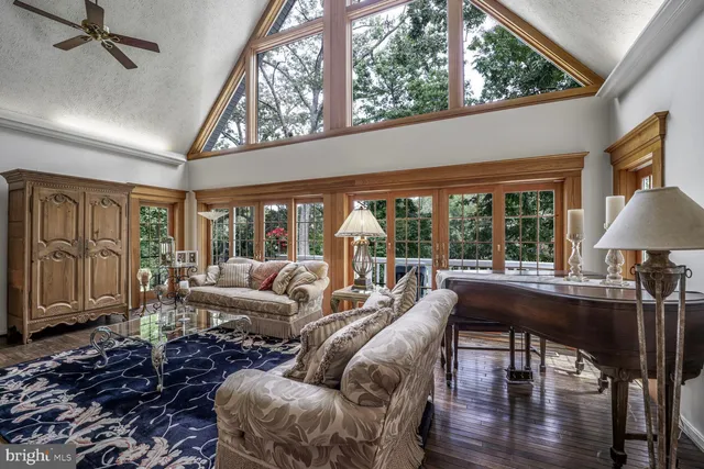 a living room with furniture ceiling fan and a large window