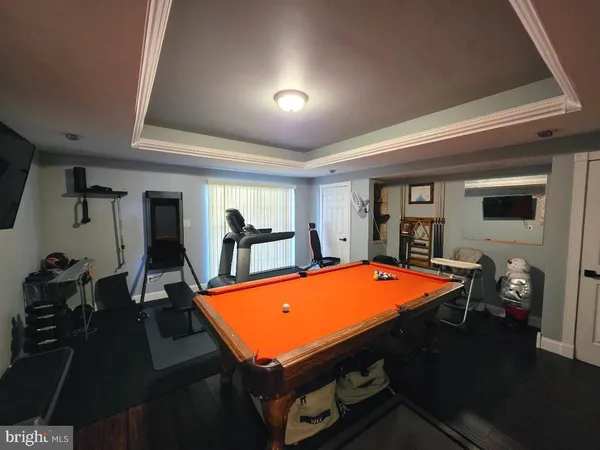 a room with pool table and wooden floor