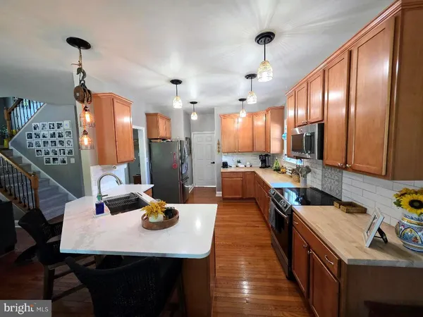 a open kitchen with stainless steel appliances granite countertop a sink a stove and refrigerator