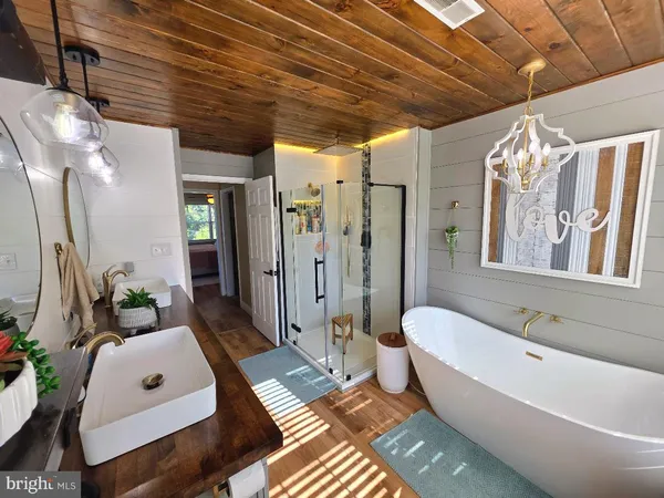 a spacious bathroom with a double vanity sink a mirror and a bathtub
