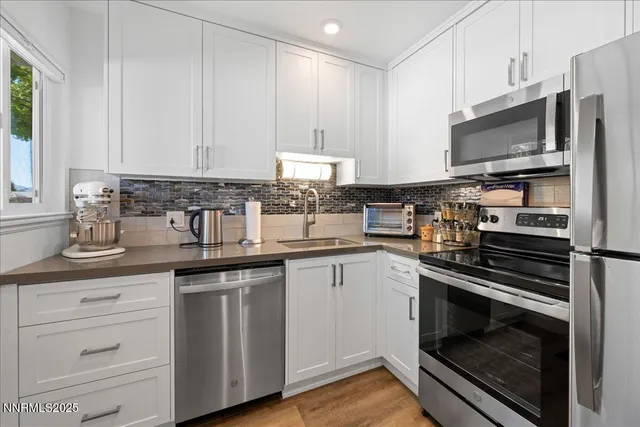 a kitchen with appliances a sink and cabinets