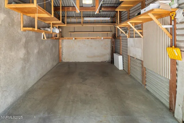 a view of a backyard with table and chairs with wooden fence and large trees