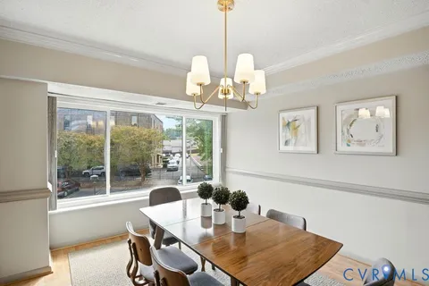 a view of a dining room with furniture wooden floor and chandelier